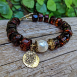 Handmade artisan Baltic amber bracelet with white Edison pearl and Spanish coin charm handcrafted by Aurora Creative Jewellery.