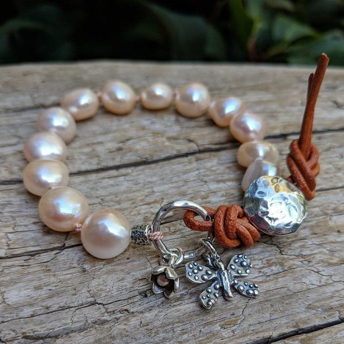 Pink pearl bracelet with butterfly and flower charms and button by Aurora Creative Jewellery