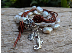 This gorgeous handmade artisan wrap bracelet-necklace combines the beautiful large white baroque pearls with sterling and leather elements. The sterling silver button, seahorse and star charms add a beautiful shine to the combination and create an ocean theme. The bracelet is held together by a silk thread and a brown leather cord. Wearing this bracelet feels like taking a refreshing walk on the beach. 