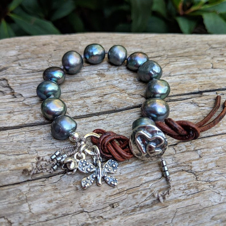Gray pearl button bracelet with a butterfly and flower charms by Aurora Creative Jewellery