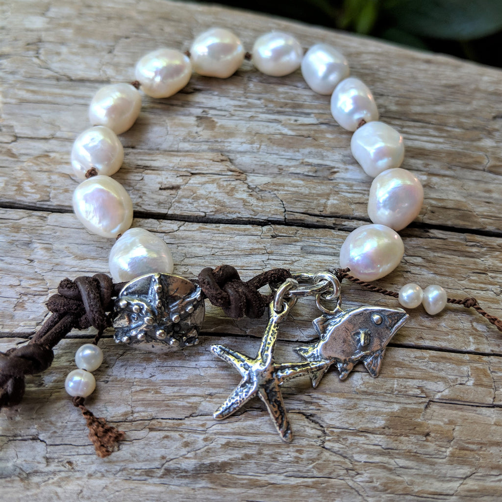 Handmade white baroque pearl bracelet with sterling silver fish and star fish charms and button by Aurora Creative Jewellery