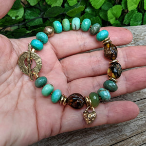 Grass green chrysoprase artisan bracelet with raw Baltic amber and gold bronze heart charm. Organic, rustic handmade bracelet. Handcrafted by Aurora Creative Jewellery.
