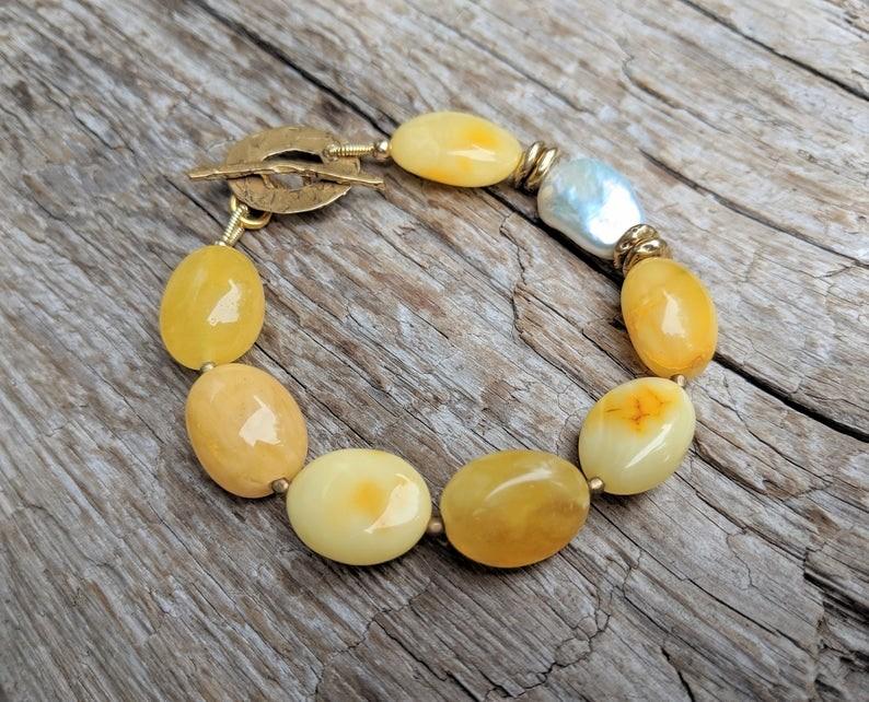 Handmade egg yolk amber and white baroque pearl bracelet with gold bronze toggle by Aurora Creative Jewellery