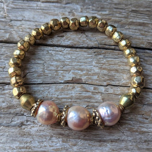 Pink pearl and African brass bracelet with gold bronze. Wear this bracelet alone or in a stack! It is elastic and very easy to put on and take off. By Aurora Creative Jewellery.
