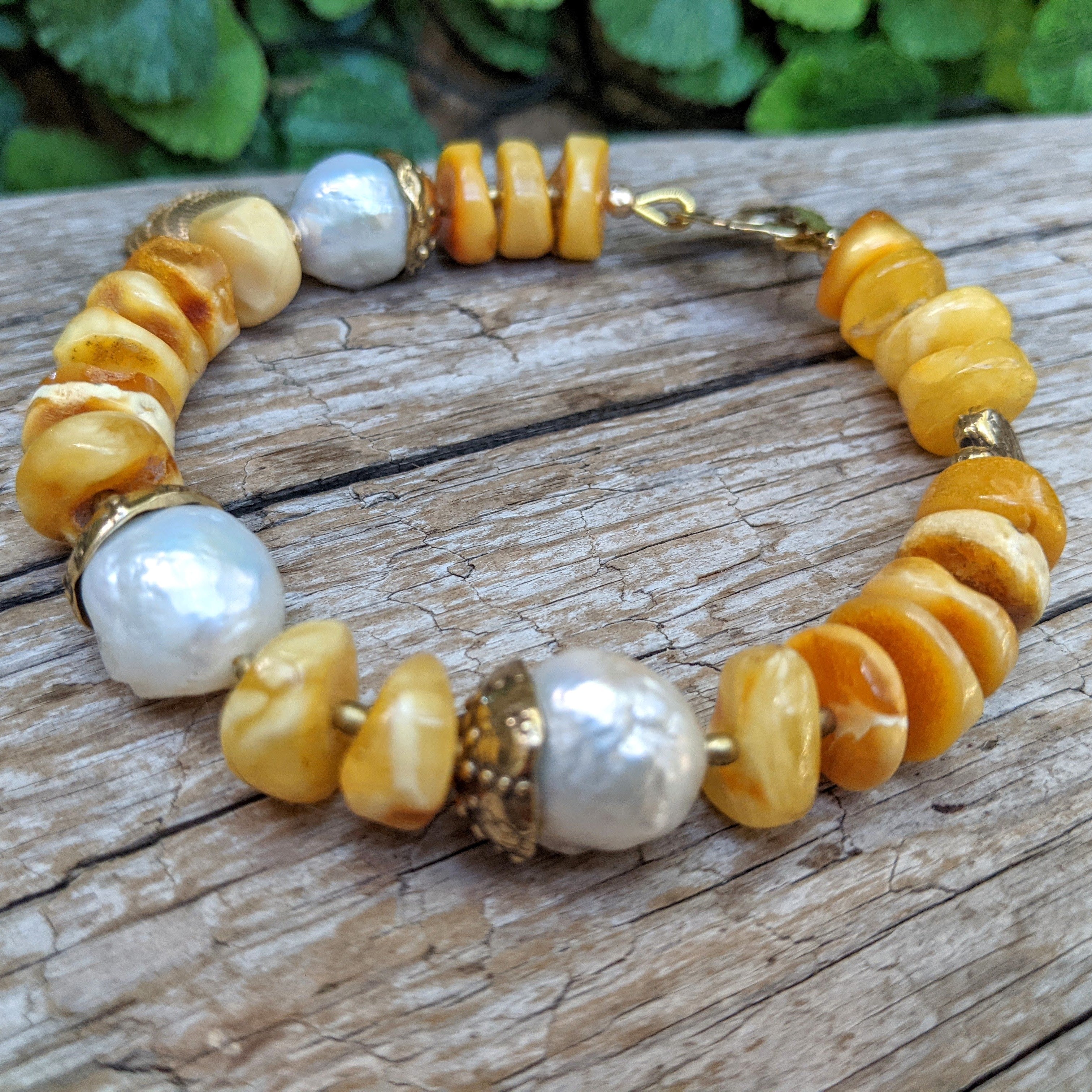 Chic and sunny amber bracelet with gold bronze sea shell and urchin created by Aurora Creative Jewellery.