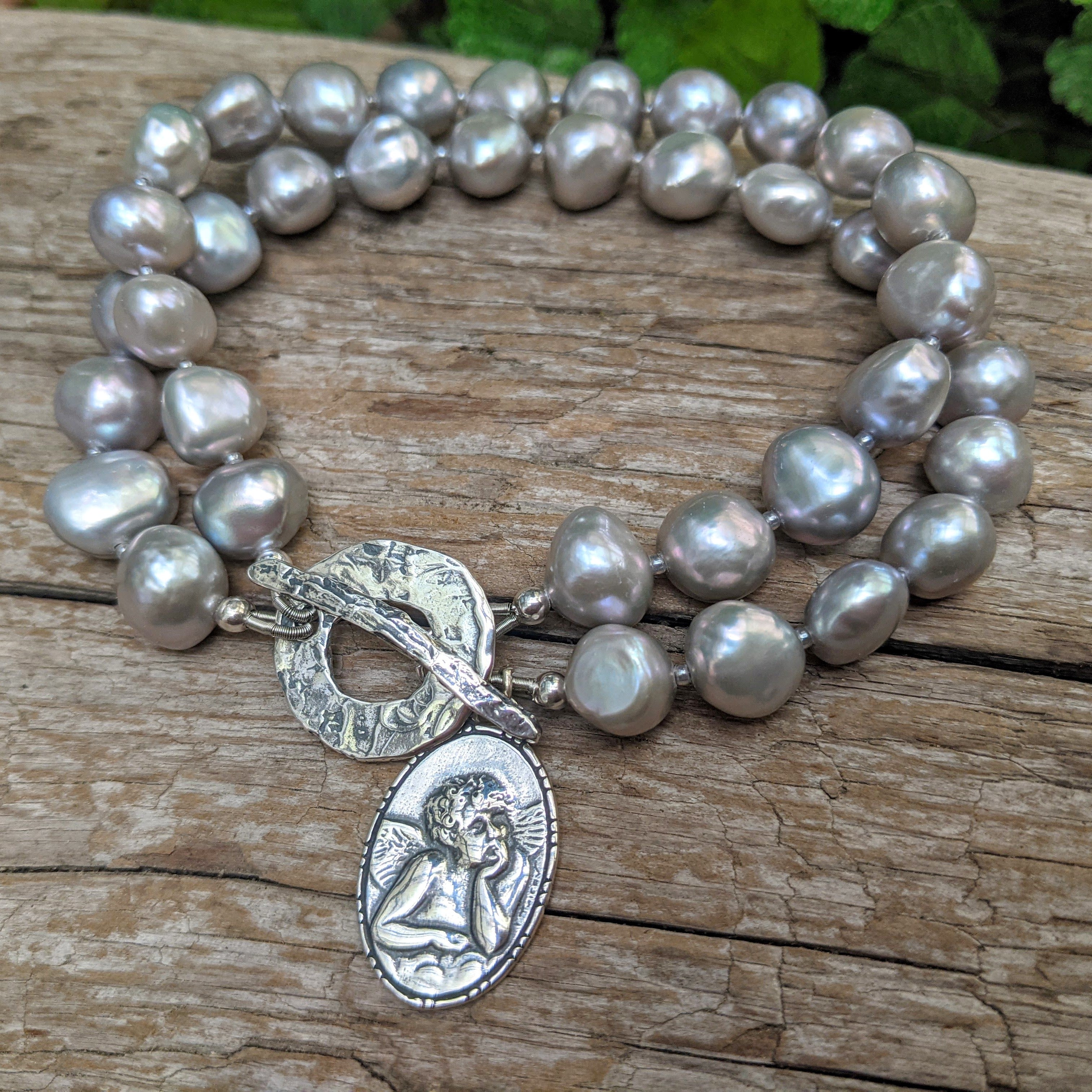 Grey pearl bracelet, Statement pearl bracelet. Boho pearl bracelet. Angel Cherub Rafael charm bracelet. Artisan , artistic pearl jewelry. Handcrafted by Aurora Creative Jewellery.  