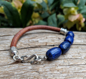 A beautiful handmade artisan bracelet featuring lapis lazuli gemstone combined with thick brown leather and sterling silver elements. The bracelet was designed with simplicity in mind, to keep the focus on the natural textures of the materials. 