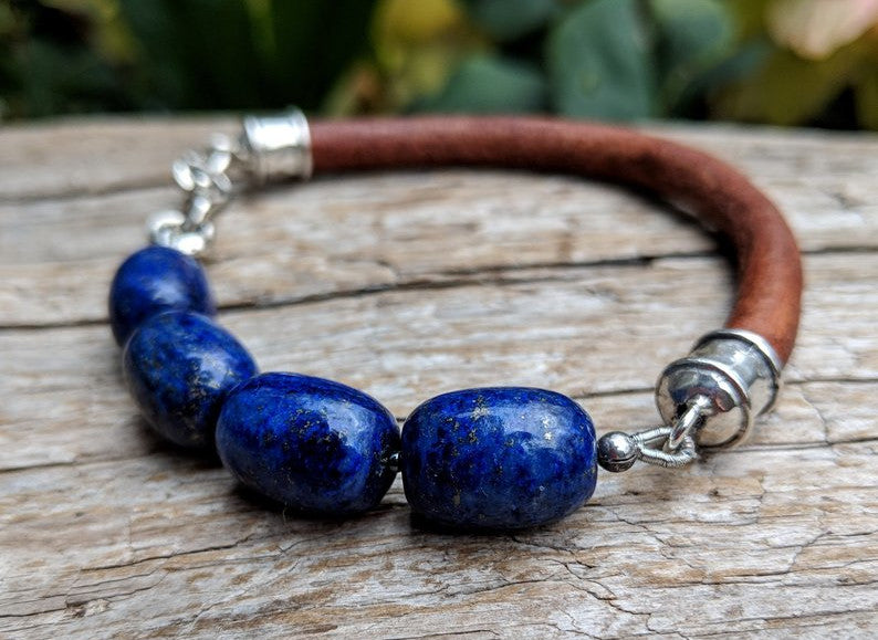 A beautiful handmade artisan bracelet featuring lapis lazuli gemstone combined with thick brown leather and sterling silver elements. The bracelet was designed with simplicity in mind, to keep the focus on the natural textures of the materials. 