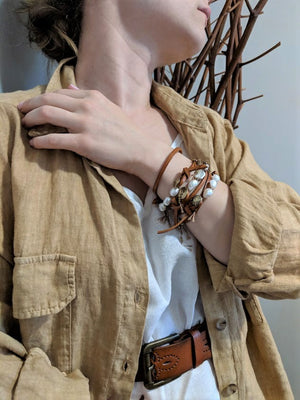 This fun handmade artisan boho leather wrap bracelet showcases the beauty of natural textures. The white baroque pearls give a pop of freshness on the background of natural leather.  The bracelet is finished off with a gold bronze button and leather loop. A heart charm adds another touch of gold and an element of fun. The heart charm can freely move around the bracelet so you can enjoy it from all sides. 