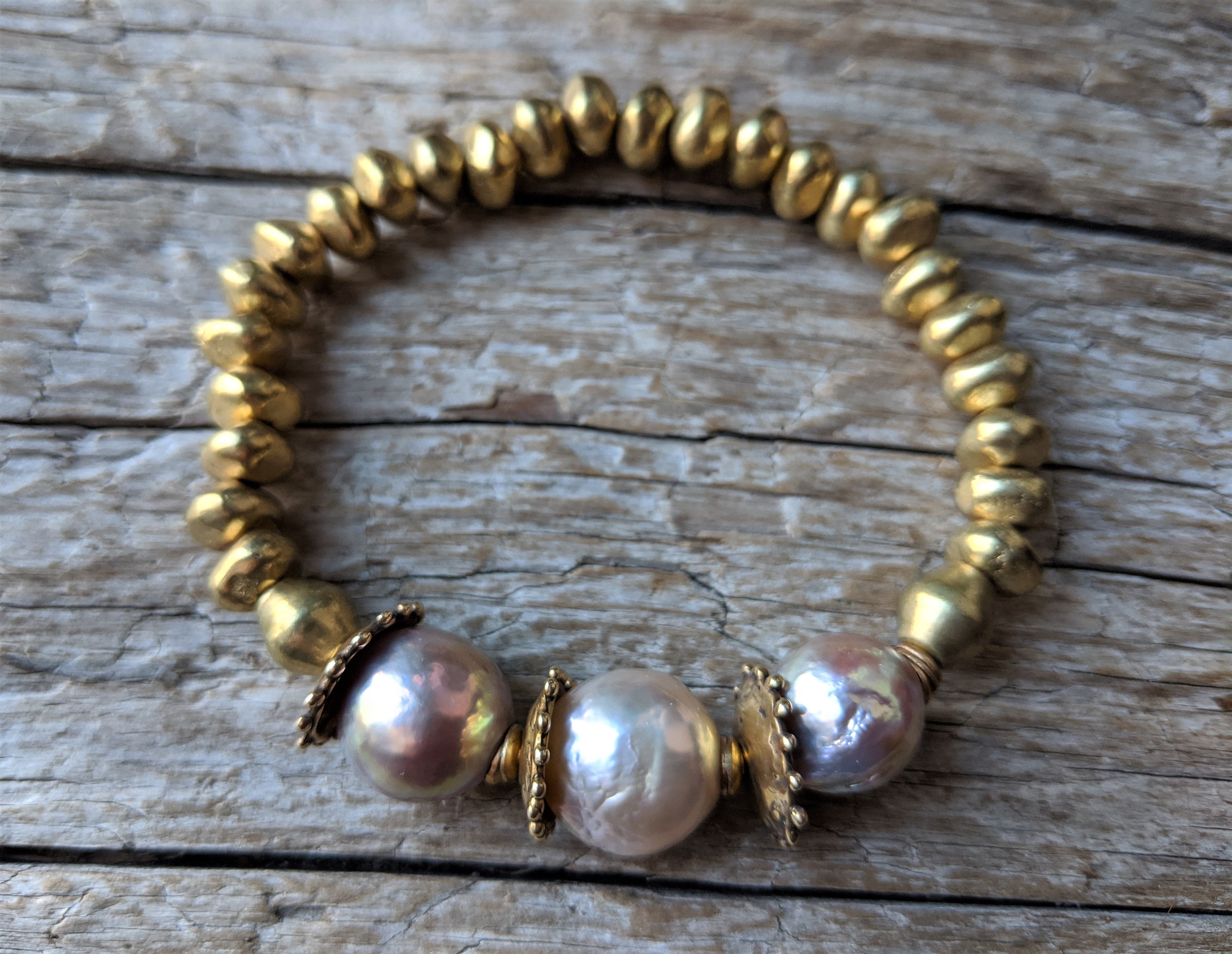 Pink pearl and African brass bracelet with gold bronze. Wear this bracelet alone or in a stack! It is elastic and very easy to put on and take off. By Aurora Creative Jewellery.