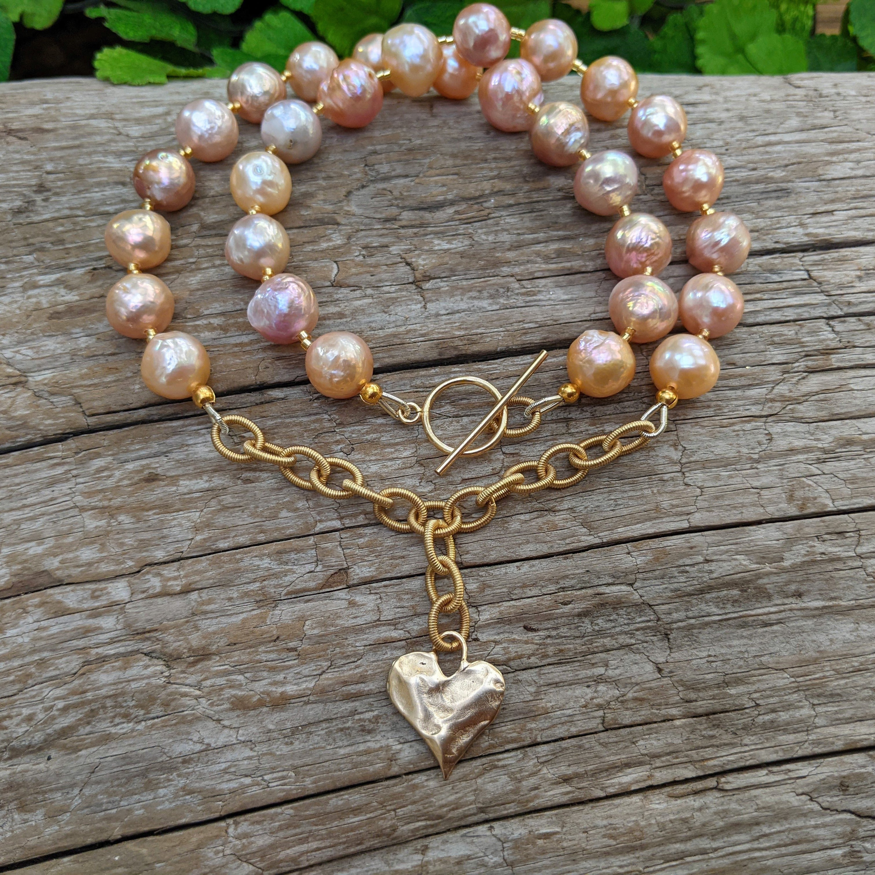 Pink Edison pearl necklace with gold bronze heart pendant. Handcrafted by Aurora Creative Jewellery.