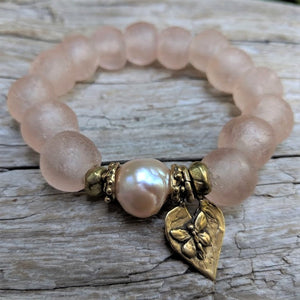 Pink pearl and sea glass elastic bracelet with gold bronze heart and butterfly with the word "Inspire" on the back of the heart. Wear this bracelet alone or in a stack! It is elastic and very easy to put on and take off. By Aurora Creative Jewellery.