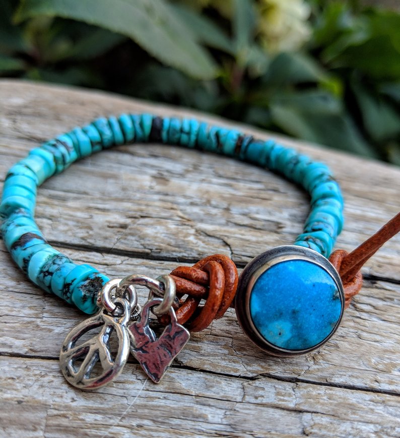 This handmade artisan turquoise bracelet showcases the Tibetan turquoise beads and turquoise button complimented by artisan sterling silver elements including the peace charm and a tiny heart. The button on this bracelet is unique as it has sterling silver setting. The button gets inserted into the leather loop to close the bracelet. A beautiful bright turquoise on your wrist contrasted by a terracotta leather accent is a perfect summer accessory. 
