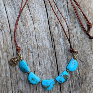 Turquoise leather necklace with gold bronze cross charm, by Aurora Creative Jewellery